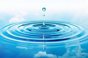 Ein Wassertropfen fällt in klares Wasser ohne Algenbildung 