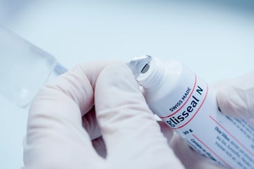 A lab technician opens a tube of glisseal N laboratory grease