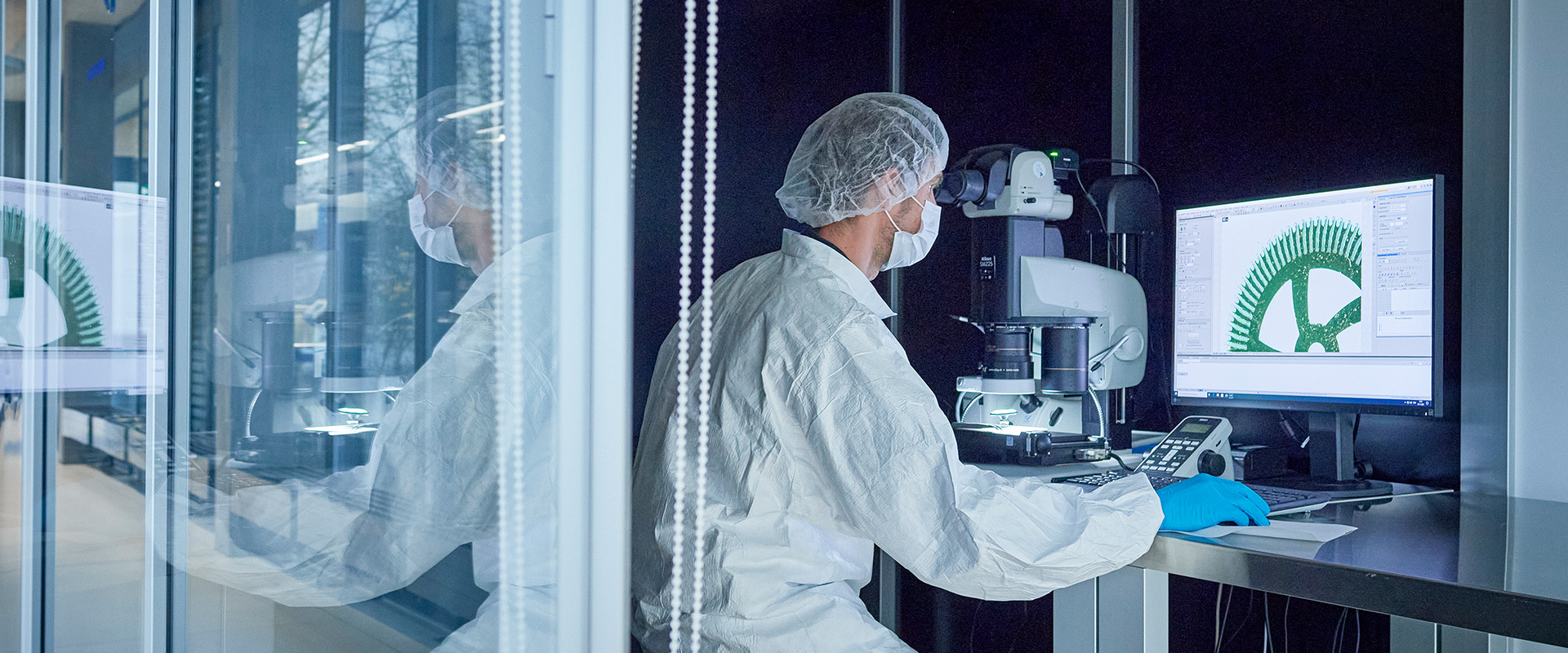 Process specialist in front of screen in clean room