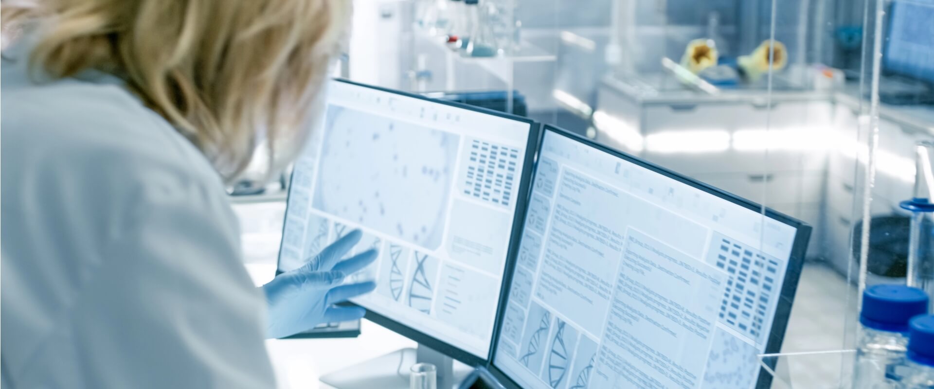 Lab technician analysing process data on a PC screen