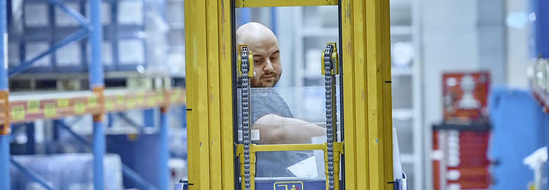 Forklift driver in the logistics high-bay warehouse